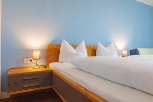 1 dormitorio con 1 cama con sábanas y almohadas blancas en Fränkische Landherberge, Hotel Garni, en Seßlach