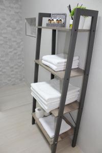 a ladder shelf with towels on it in a bathroom at Loft Azalea in Córdoba