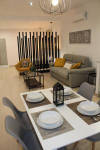sala de estar con mesa, sillas y sofá en Loft Azalea, en Córdoba