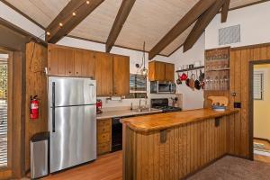 a kitchen with a stainless steel refrigerator and wooden cabinets at 021 - Tree Fort Getaway in Big Bear City