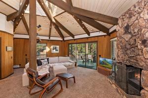 a living room with a fireplace and a stone wall at 021 - Tree Fort Getaway in Big Bear City