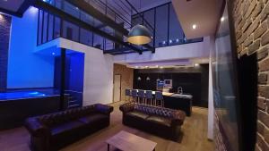 a living room with leather chairs and a bar at loft d architecte spa sauna billard 12 places ultra contemporain in Ferrière-la-Grande +14 photos