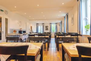 Fränkische Landherberge, Hotel Garni في Seßlach: مطعم بطاولات وكراسي خشبية وطاولة طعام