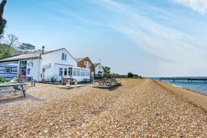 un edificio a orillas de una playa con bancos en Starboard, en Yarmouth
