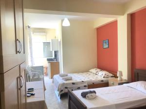 a hotel room with two beds and a kitchen at Veizi's Apartments in Himare
