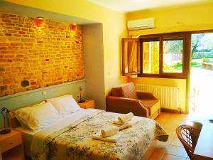 um quarto com uma cama e uma parede de tijolos em Rent Rooms Alexiou em Límni