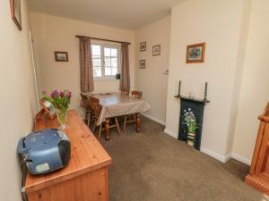 a living room with a table and a fireplace at Bellafax Cottage in Kirby Misperton