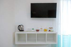 un estante blanco con un televisor encima. en Villa Maìki en Torca