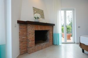 a living room with a brick fireplace with a vase on it at Villa Maìki in Torca