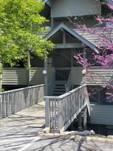 a gray house with a wooden porch and stairs at Treehouse Condos - Branson in Branson