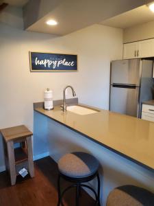 a kitchen with a counter with a sink and a refrigerator at Treehouse Condos - Branson in Branson