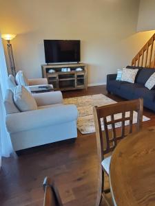 a living room with a couch and a tv at Treehouse Condos - Branson in Branson