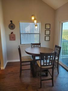 a dining room with a table and chairs and a window at Treehouse Condos - Branson in Branson