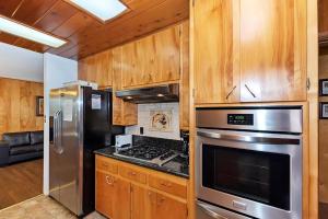 a kitchen with stainless steel appliances and wooden cabinets at 049 - Mountain Time in Big Bear Lake
