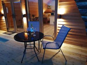 una mesa y dos sillas con copas de vino. en Tollymore Luxury log cabins, en Newry