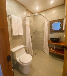 a bathroom with a white toilet and a sink at Hotel Gio in Sonsón