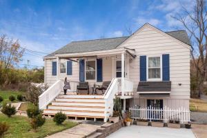 a white house with a porch and stairs at Cozy house to call home away from home in Maryland Heights