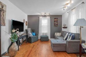 a living room with a couch and a tv at Cozy house to call home away from home in Maryland Heights