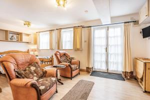 Una sala de estar con dos sillas y un televisor. en Sail Loft Annexe, en Yarmouth