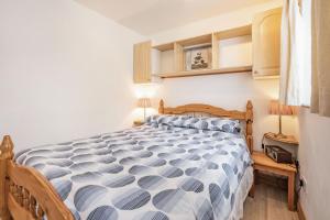 een slaapkamer met een bed met een blauw en wit dekbed bij Sail Loft Annexe in Yarmouth