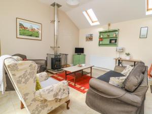 a living room with two chairs and a table at 1 Pines Farm Cottages in Ulleskelf