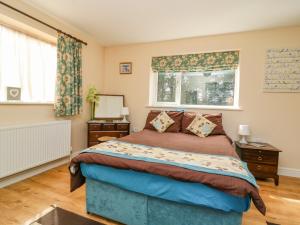 a bedroom with a bed and two night stands at 1 Pines Farm Cottages in Ulleskelf