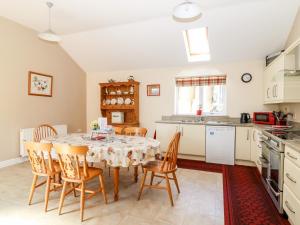 una cucina e una sala da pranzo con tavolo e sedie di 2 Pines Farm Cottages a Ulleskelf