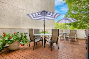 een tafel en stoelen met parasols op een terras bij La Residence Suite Hotel in Bellevue