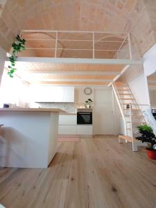 une chambre avec une mezzanine avec un escalier et une cuisine dans l'établissement Fico apartment, à San Vito dei Normanni