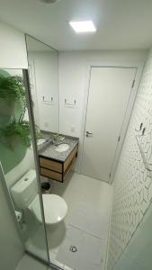 a white bathroom with a toilet and a sink at Apartamento para renovar as energias - Cama Queen in São Paulo