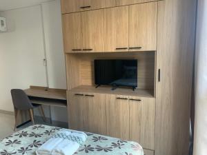 a bedroom with a cabinet with a tv and a bed at “SC Apartments” Equipetrol in Santa Cruz de la Sierra