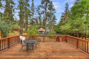 a wooden deck with chairs and a table on it at 074 - Pinetree Retreat in Big Bear Lake