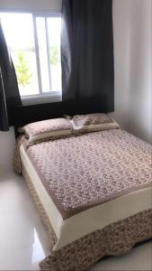a small bed in a room with a window at brisas da maré in Passo de Torres