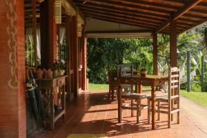 a patio with a table and chairs on a house at Pousada Encanto da Bocaina - Serra da Bocaina in São José do Barreiro