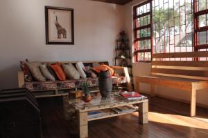 uma sala de estar com um sofá e uma mesa em Hostal Triangulo del Café em Manizales