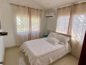 1 dormitorio con 1 cama y 2 ventanas en Posada Vasquez Oviedo, en San Andrés