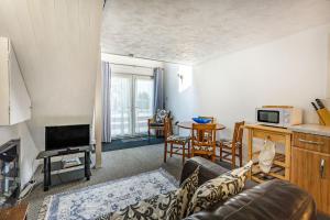 a living room with a couch and a tv at West Sea View No 4 in Yarmouth