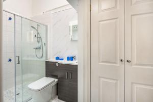 een badkamer met toilet en glazen douche bij West Sea View No 4 in Yarmouth +9 foto's