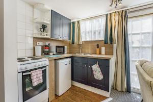 een kleine keuken met een fornuis en een spoelbak bij West Sea View No 5 in Yarmouth