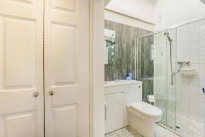 een witte badkamer met toilet en douche bij West Sea View No 5 in Yarmouth +13 foto's
