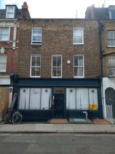 un edificio de ladrillo con puertas blancas y una bicicleta estacionada fuera en Central London flat. Georgian Terrace. Bright., en Londres