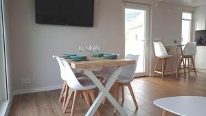 a dining room with a table with chairs and a television at Vila Mariña. Casa marinera con terraza sobre el mar en Caión in Cayón +38 photos