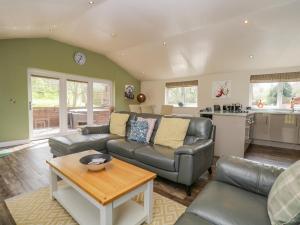 a living room with a couch and a table at Cartmel Lodge in Cartmel