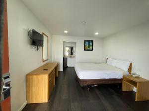 a small room with a bed and a television at Palms Inn & Suites in Palmdale