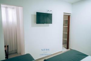 een woonkamer met een tv aan de muur bij Neos Hotel Cartagena in Cartagena