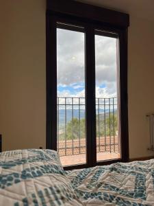 a bedroom with a bed and a window with a view at Alquería de Segur a in Segura de la Sierra