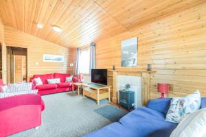 a living room with red furniture and wooden walls at Rosy Lodge in Milford on Sea