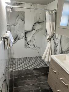 a bathroom with a shower with a marble wall at Miami Inn & Suites in Chicago