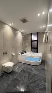 La salle de bains est pourvue d'une baignoire, de toilettes et d'un lavabo. dans l'établissement شاليهات سنتارا, à Taif