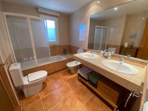 ein Badezimmer mit zwei Waschbecken, einem WC und einem Spiegel in der Unterkunft house on the beach in Calafell